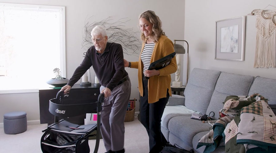 Woman helping a man with his wheelchair.