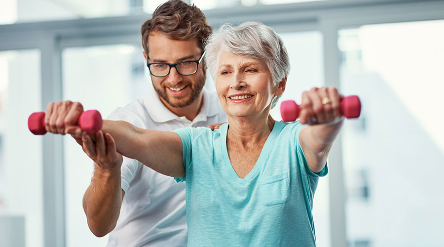 Woman being assisted in lifting weights.