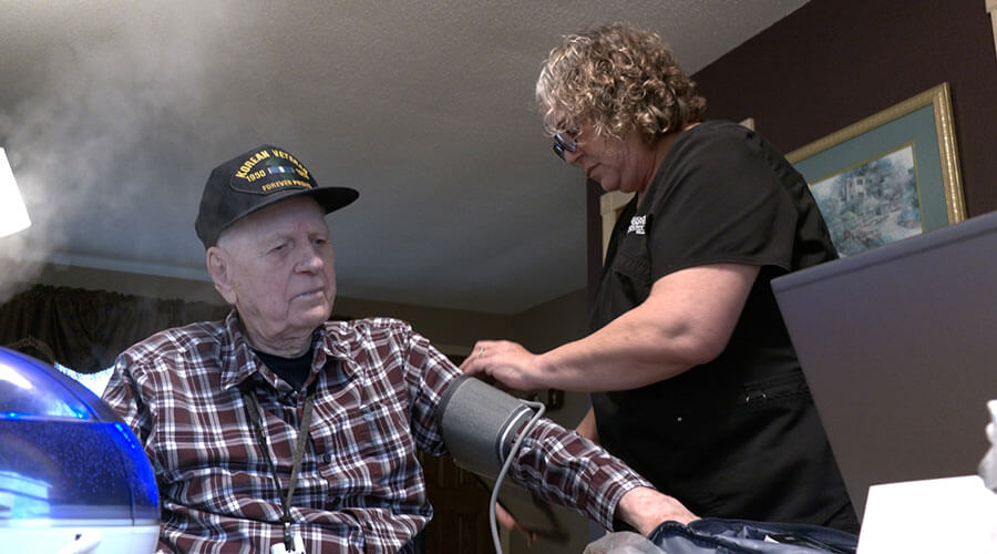 Good Samaritan home health nurse Kellie Plutowski checks the blood pressure of Thor Sannes during a visit.