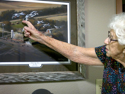 June Reed pointing at her painting.