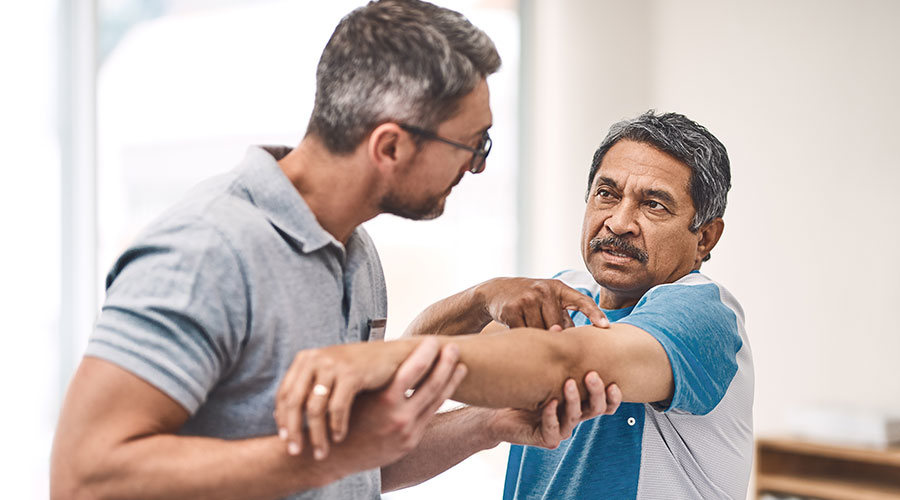 Patient pointing to his arm during rehabilitation session.