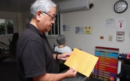 Randy Kimura shows the sheet that he and his mother-in-law, Janet Nakashima, use to keep track of her workouts.