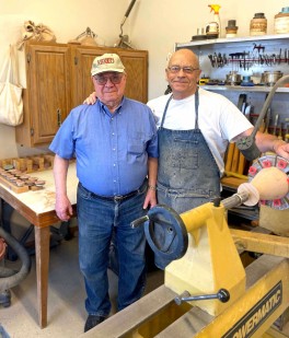 Two men stand in a woodshop