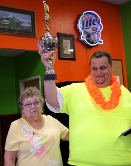 Dan Pulak raises his trophy after being recognized for his work as the top fundraiser for Good Sam Bowl in Brainerd, Minnesota.