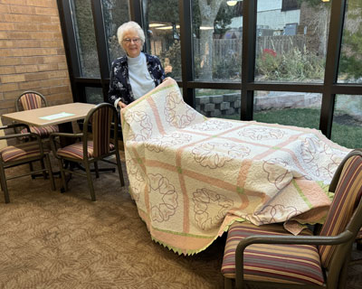 Idamae Hauf holding her quilt.