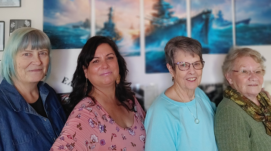 Four women standing in front of the veterans' wall at Spokane Valley