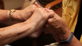 Joann Kloos holding hands with a resident at Good Samaritan Society – Ambassador.