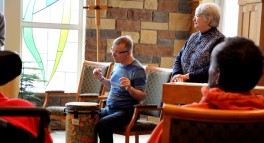 Fred is playing the drums which soothe his struggle with Huntington's disease. 