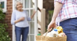 Aide bringing groceries to woman's home
